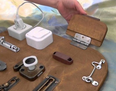 DIY-Entwicklungsboards für Kinder. So stellen Sie ein Busy Board her und befestigen Klettverschlüsse und Knöpfe. Foto