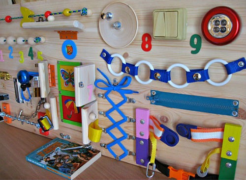 DIY-Entwicklungsboards für Kinder. So stellen Sie ein Busy Board her und befestigen Klettverschlüsse und Knöpfe. Foto
