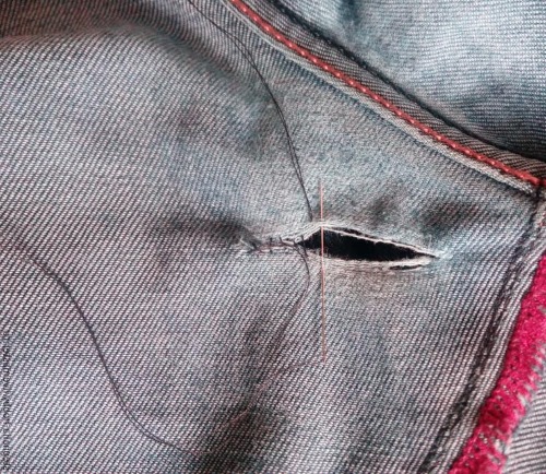 So stopfen Sie Jeans zwischen den Beinen mit der Maschine und von Hand schön fest. Foto