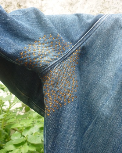 So stopfen Sie Jeans zwischen den Beinen mit der Maschine und von Hand schön fest. Foto