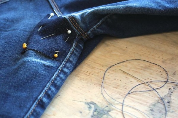 So stopfen Sie Jeans zwischen den Beinen mit der Maschine und von Hand schön fest. Foto