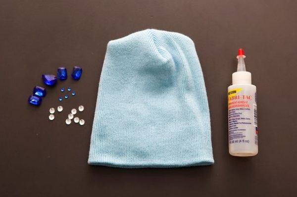So verzieren Sie eine Strickmütze für Damen mit Perlen, Pelz, Strasssteinen und Rocailles. Foto