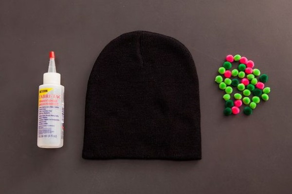So verzieren Sie eine Strickmütze für Damen mit Perlen, Pelz, Strasssteinen und Rocailles. Foto