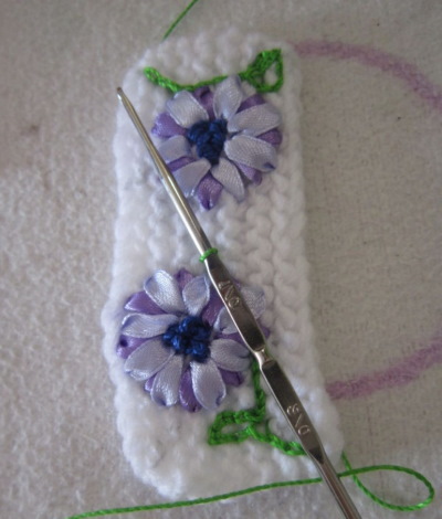 So verzieren Sie eine Strickmütze für Damen mit Perlen, Pelz, Strasssteinen und Rocailles. Foto
