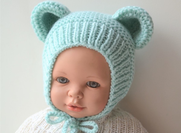 Gestrickte Mütze für Neugeborene. Muster von durchbrochenen Hüten für Mädchen, Jungen