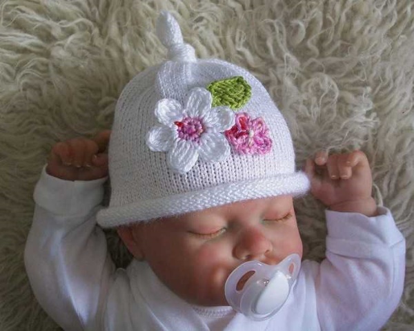 Gestrickte Mütze für Neugeborene. Muster von durchbrochenen Hüten für Mädchen, Jungen
