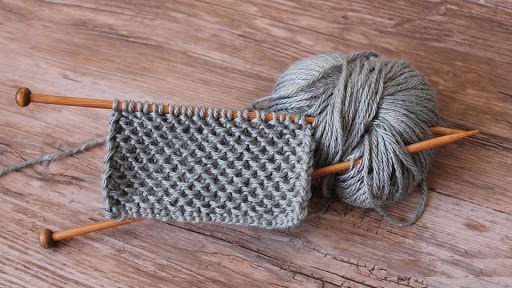 Perlenstricken. Muster und Beschreibung, Strickmuster für einen Snood, eine Strickjacke, eine Mütze, einen Pullover. Foto