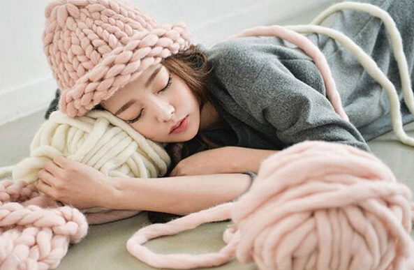 Un grande cappello di lana fatto con fili spessi e ferri da maglia. Schema