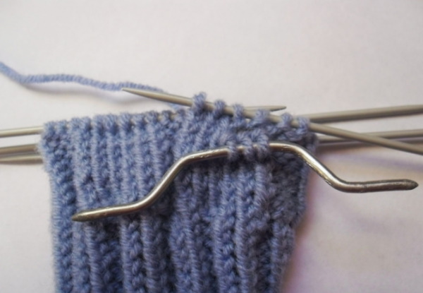 Fäustlinge gestrickt. Muster mit Beschreibungen zum Stricken mit Zöpfen, durchbrochenen, langen
