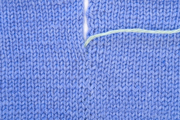 Gestrickte Masche beim Stricken. Kreisläufe schließen, verbinden