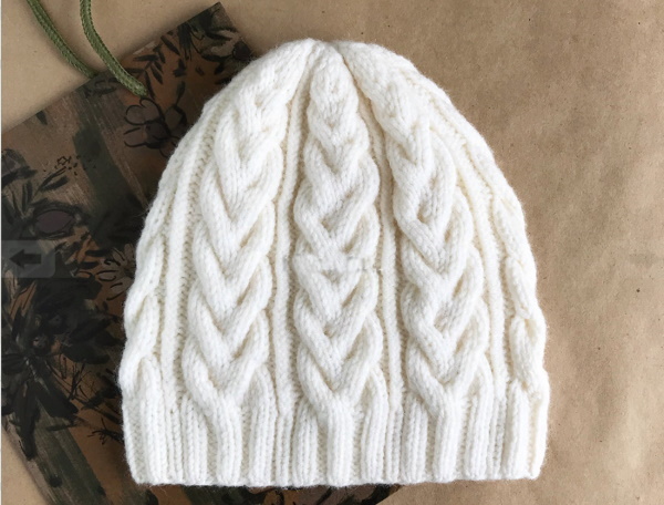 Mit Stricknadeln Maschen an einer Mütze abnehmen. Muster mit glatt rechts, 2x2, 1x1 Gummiband