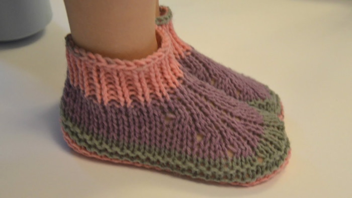 Baby-Fußabdrücke auf zwei Stricknadeln